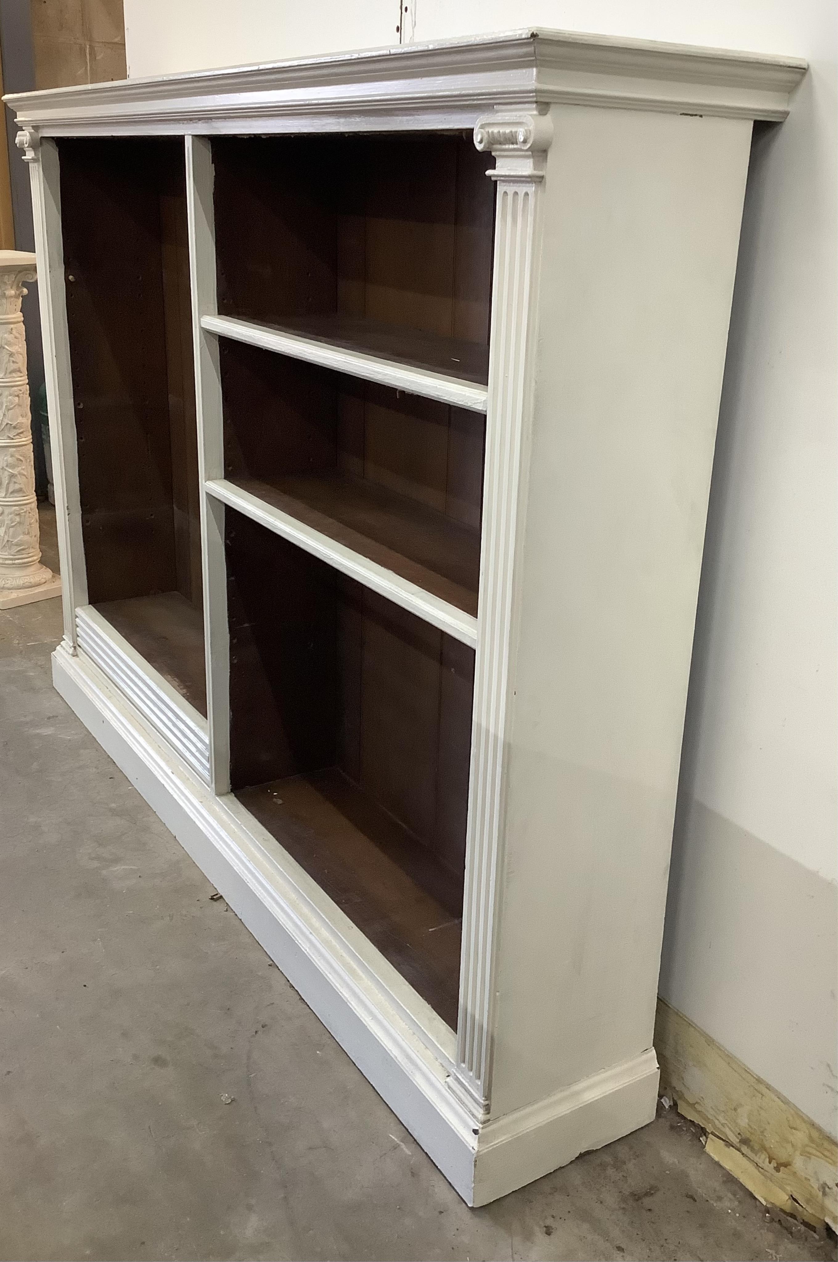 A late Victorian oak open shelved two section bookcase, later painted, width 183cm, depth 35cm, height 132cm. Condition - poor